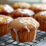 Maple glazed donut muffins cooling on a kitchen counter.