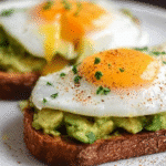 Delicious avocado toast topped with a perfectly fried egg on a rustic plate