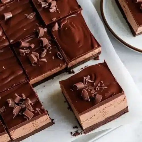 Delicious Chocolate Mousse Brownies served on a plate, drizzled with chocolate sauce.