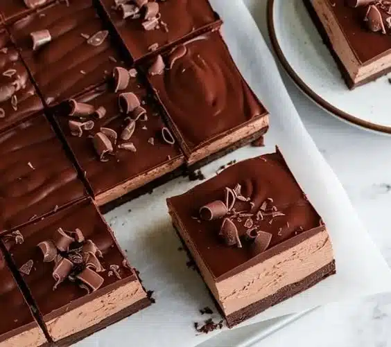 Delicious Chocolate Mousse Brownies served on a plate, drizzled with chocolate sauce.