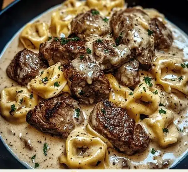 Cracked garlic steak tortellini in a creamy sauce with herbs and spices