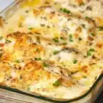 Delicious creamy baked chicken breasts served with herbs and vegetables.
