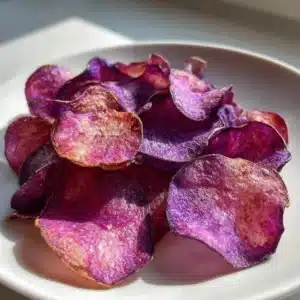 Bowl of crispy air fryer purple potato chips served on a table