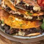 Crispy black bean tacos topped with fresh ingredients on a plate