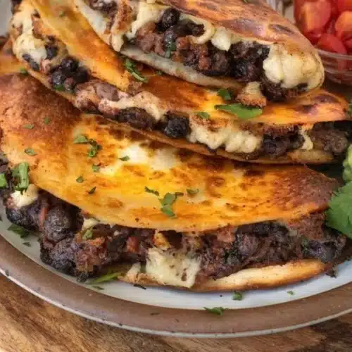 Crispy black bean tacos topped with fresh ingredients on a plate