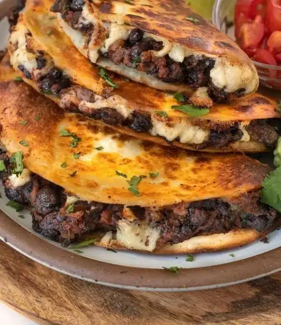 Crispy black bean tacos topped with fresh ingredients on a plate