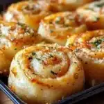 Garlic Parmesan New York Pizza Rolls served on a wooden board with herbs