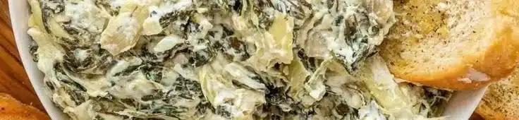 Creamy Crockpot Spinach Artichoke Dip served in a bowl with tortilla chips