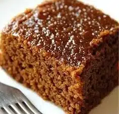 Quick and easy gingerbread cake fresh out of the oven topped with icing.