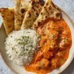 Delicious homemade butter chicken served with naan and rice