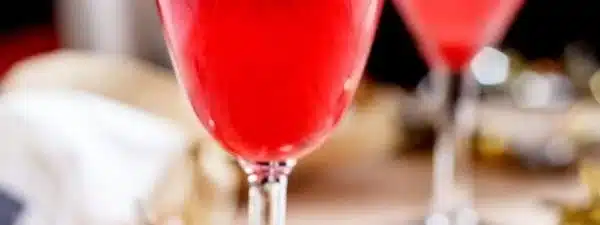 Raspberry Champagne cocktail garnished with fresh raspberries and mint leaves