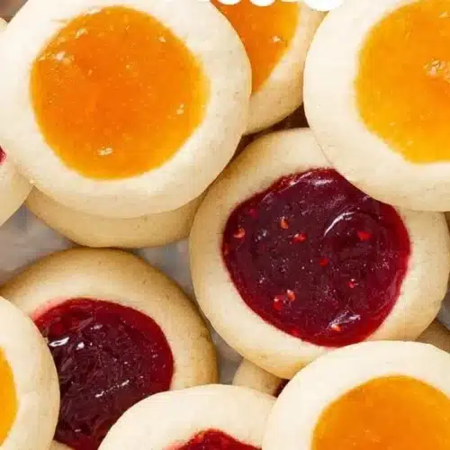 Delicious homemade thumbprint cookies with jam filling on a baking tray