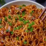 A delicious bowl of egg roll in a bowl topped with fresh vegetables and savory sauce.