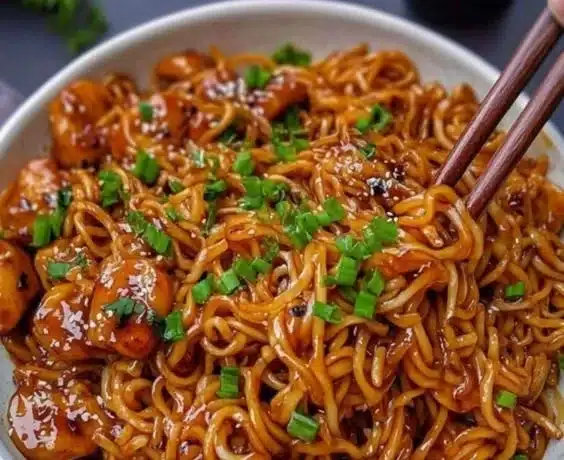 A delicious bowl of egg roll in a bowl topped with fresh vegetables and savory sauce.