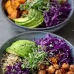 A vibrant vegan bowl filled with colorful vegetables, grains, and fresh herbs.