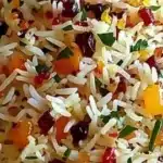 Bowl of Persian Jeweled Rice garnished with nuts and dried fruits