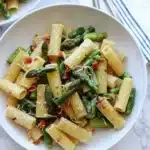 Delicious pasta dish with asparagus and sun dried tomatoes, garnished elegantly.