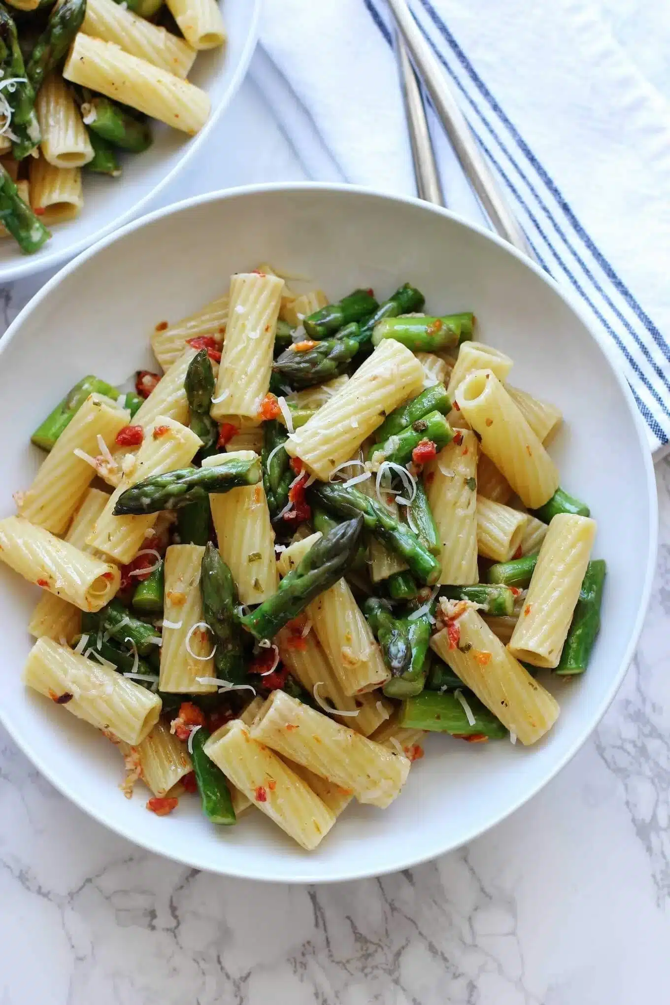 Delicious pasta dish with asparagus and sun dried tomatoes, garnished elegantly.