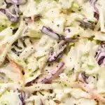 Bowl of colorful coleslaw with cabbage, carrots, and dressing