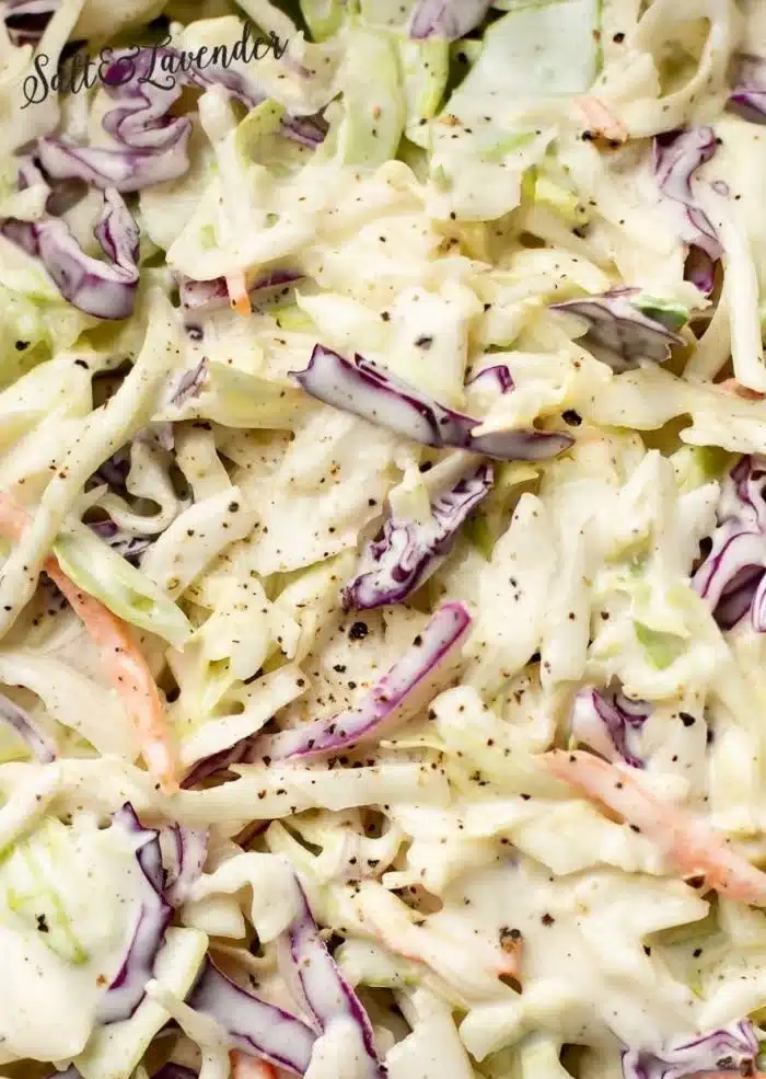 Bowl of colorful coleslaw with cabbage, carrots, and dressing