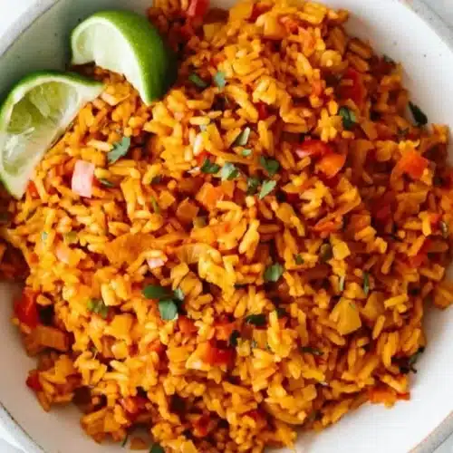 Plate of easy Mexican rice garnished with cilantro and lime