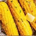 Grilled corn on the cob wrapped in foil for BBQ cooking