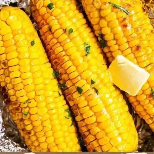 Grilled corn on the cob wrapped in foil for BBQ cooking