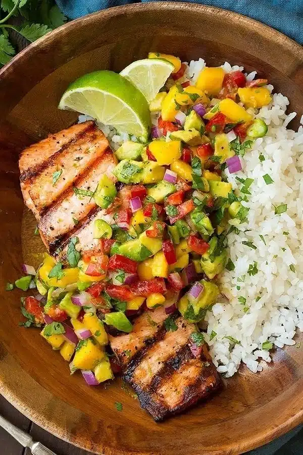 Grilled salmon topped with mango salsa served alongside coconut rice