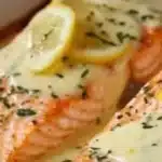 Baked salmon fillet with lemon butter cream sauce drizzled on top