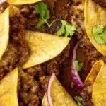 A delicious plate of crispy ground beef tacos topped with fresh ingredients