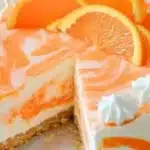 No-Bake Orange Creamsicle Cheesecake topped with orange slices and whipped cream.