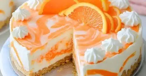 No-Bake Orange Creamsicle Cheesecake topped with orange slices and whipped cream.