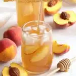 A refreshing glass of Southern Style Fresh Peach Sweet Tea with fresh peaches