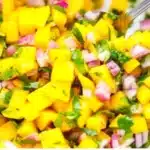 Bowl of fresh mango salsa with diced mango, onions, and cilantro
